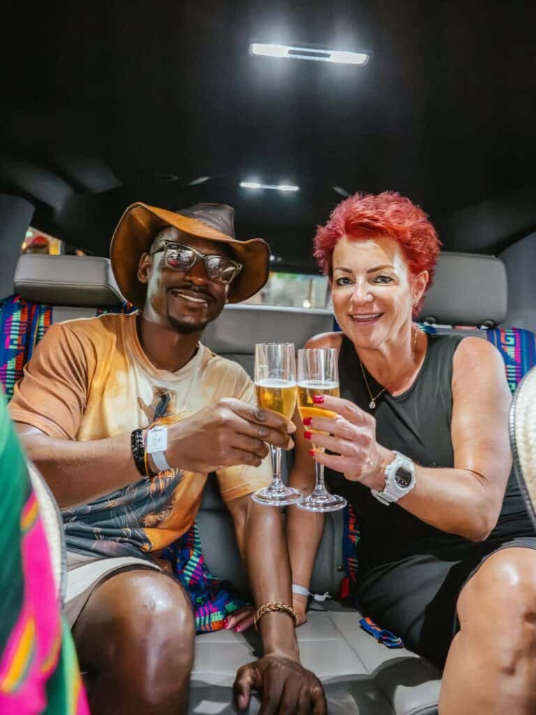 Two guests toasting with champagne inside a limousine in Los Cabos.