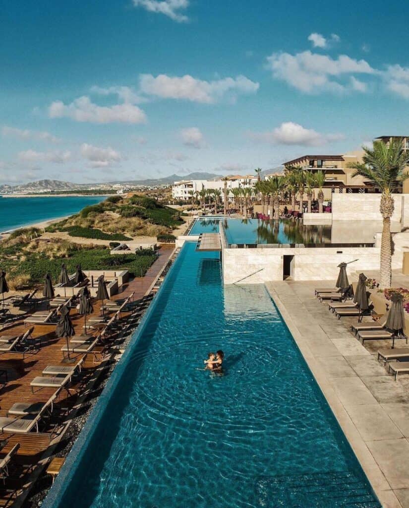 A long infinity pool running beside the beach