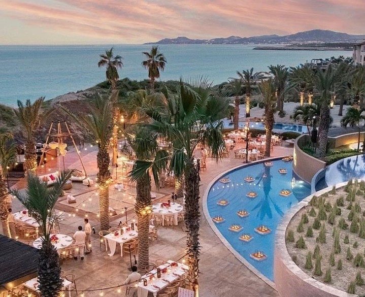 Terraces and a lit pool at dusk facing the Sea of Cortez