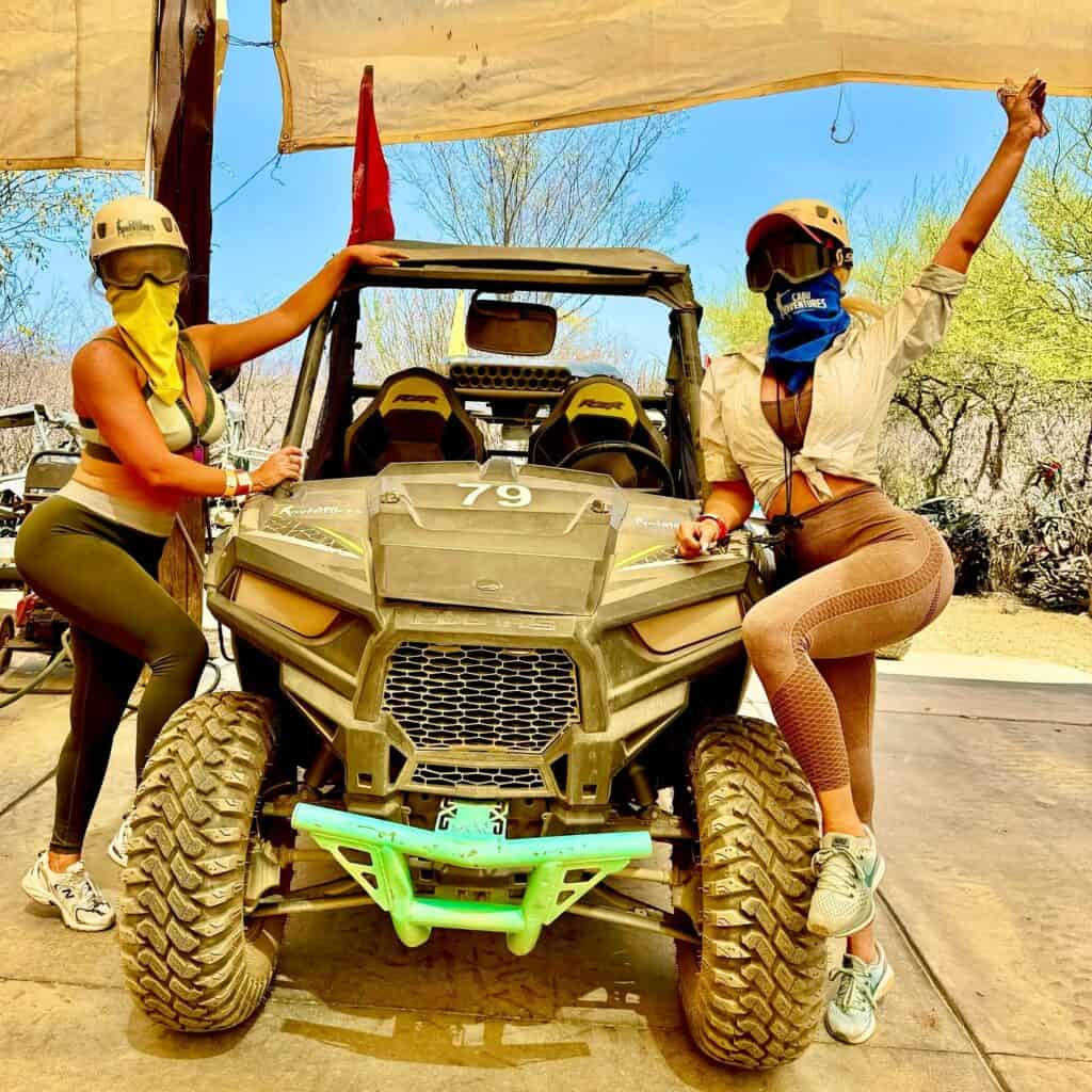 Two travellers beside a UTV before a desert ride in Los Cabos.