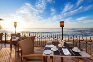 Breakfast tables on the 7 Seas terrace above Acapulquito Beach, with waves breaking offshore