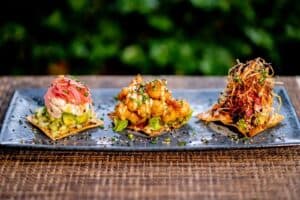 Three seafood tostadas on a slate plate at 7 Seas