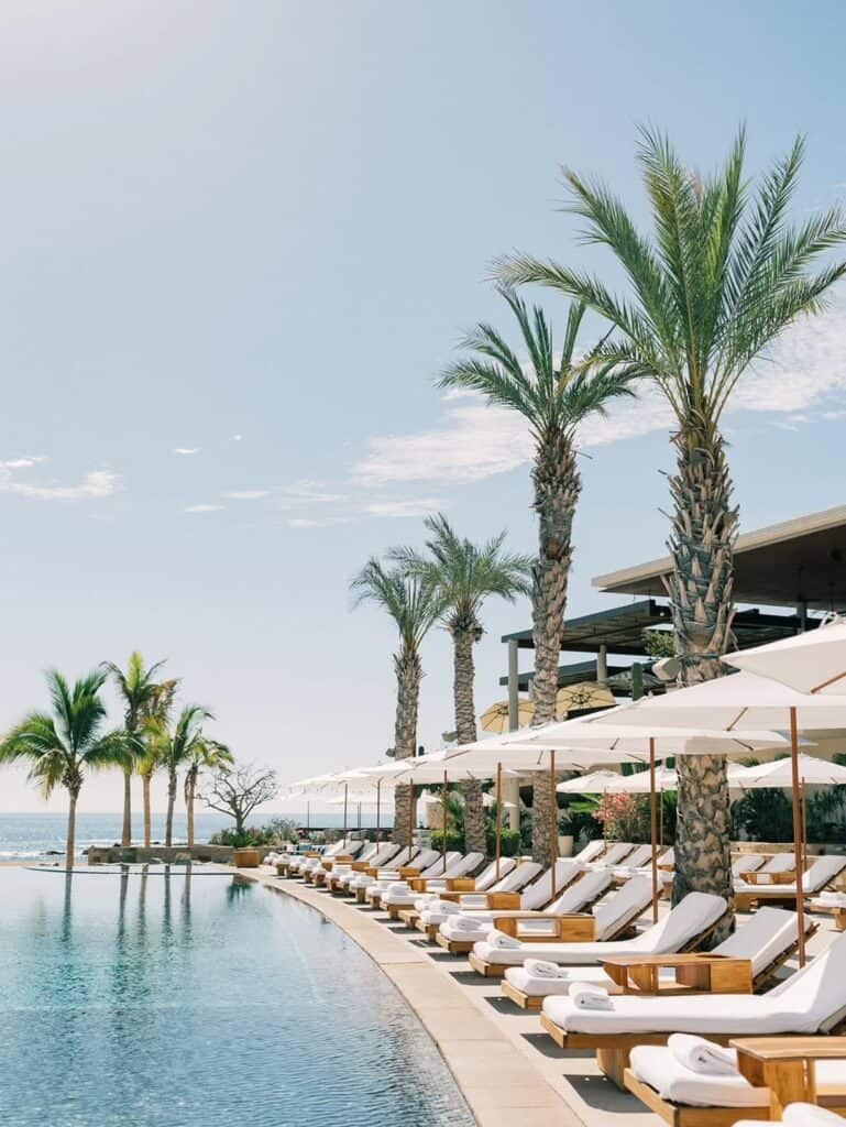Palm trees and loungers beside the pool at Chileno Bay Resort and Residences