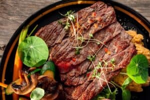 Seared flank steak strips over a mash with mushrooms, zucchini and nasturtium leaves at The Green Room