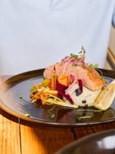 Grilled salmon on mashed potatoes with julienned vegetables and lemon at Jack's Steak House