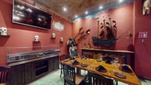 A corner of Jack's Steak House with a model galleon, skulls and a pirate figure against the red walls
