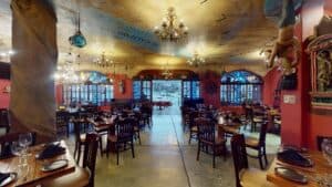 Set tables in the dining room at Jack's Steak House, looking toward the arched windows and the door to the marina