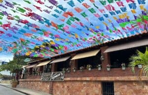 The brick front of Jazmin's Restaurant on Calle Morelos by day, under rows of colored papel picado