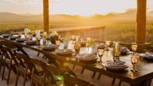 A long dinner table set on the covered terrace at Monte Cardón as the sun goes down over the desert and the mountains