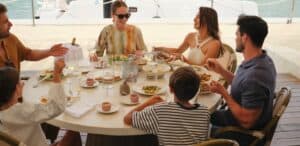 A family sharing plates at a round table on the marina-side deck at Mozza Baja