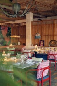 The private dining room at Mozza Baja, with an octopus chandelier, wooden screens and red chairs