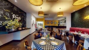 The indoor dining room at Presto, with a chalkboard mural of Italian ingredients and lemon branches on the counter