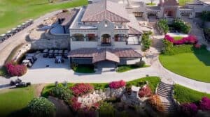Aerial view of the El Cardonal clubhouse at Diamante, home of The Woods Cabo above the golf shop, with golf carts and gardens