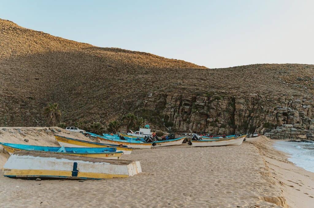 Fishing pangas pulled up on the sand below the cliff at Playa Punta Lobos