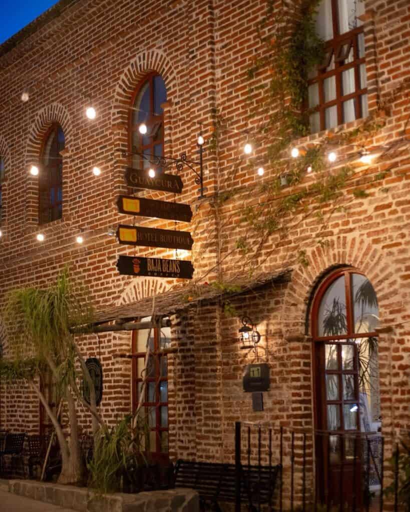 The brick facade of Guaycura Boutique Hotel in Todos Santos lit at night