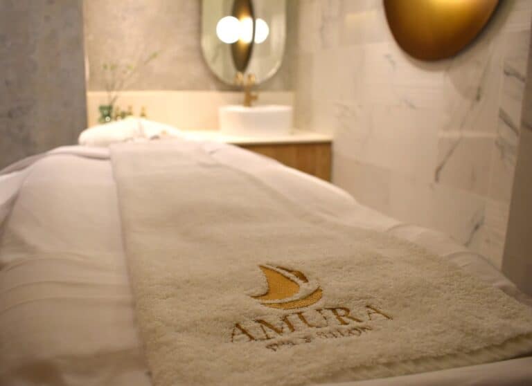 Towel embroidered with the Amura Spa and Salon logo on a massage table