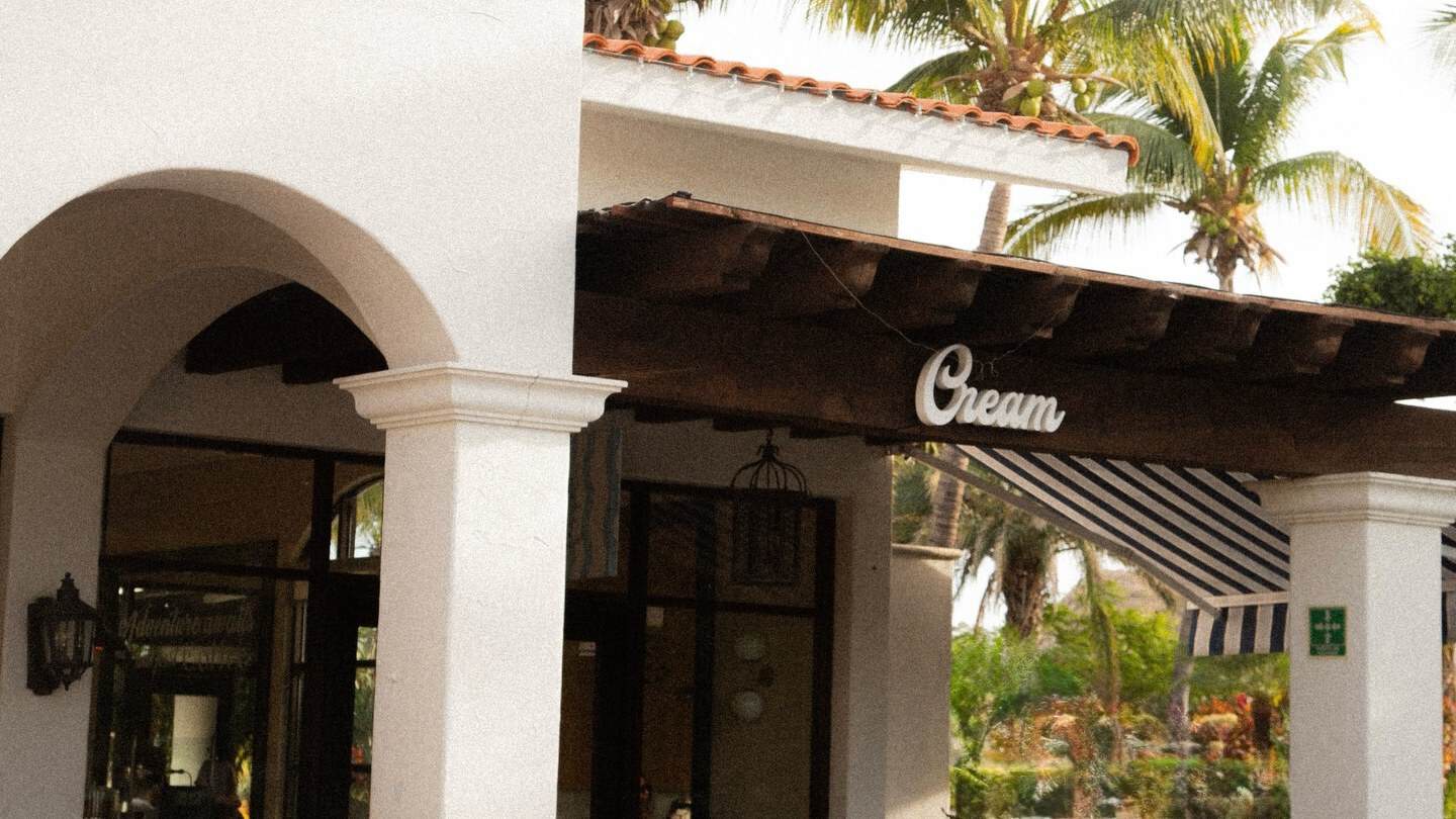 The white arches and the Cream sign at the entrance of Cream Palmilla, The Shoppes at Palmilla