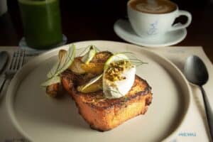 Cream French toast with apple, a mascarpone quenelle and pistachios on a white plate at Cream