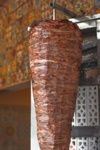 The al pastor trompo in front of a talavera tile wall at Las Guacamayas