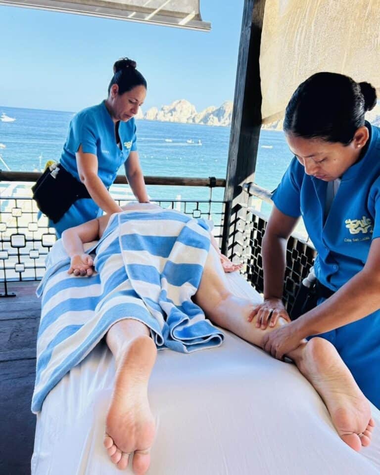 Two therapists giving a four-hand massage on the deck above Médano Beach