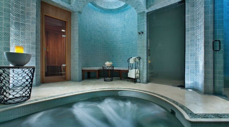 Whirlpool with sauna and steam room doors in the tiled wet area at Waldorf Astoria Spa