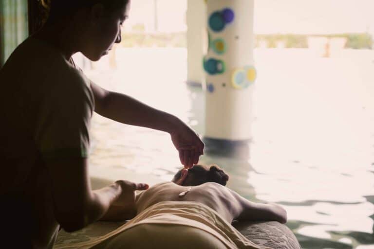 Therapist giving a massage beside the spa pool at Waldorf Astoria Spa