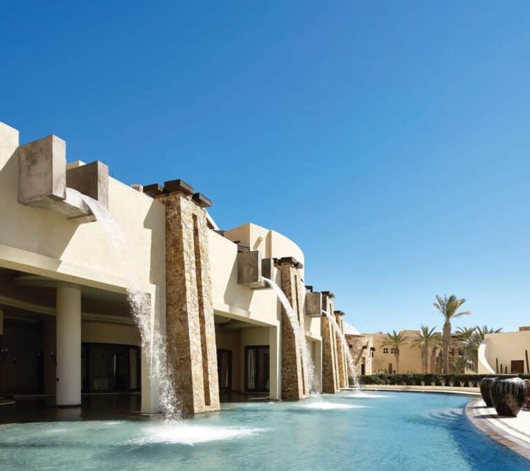Waterfalls pouring into the lagoon pool outside Waldorf Astoria Spa