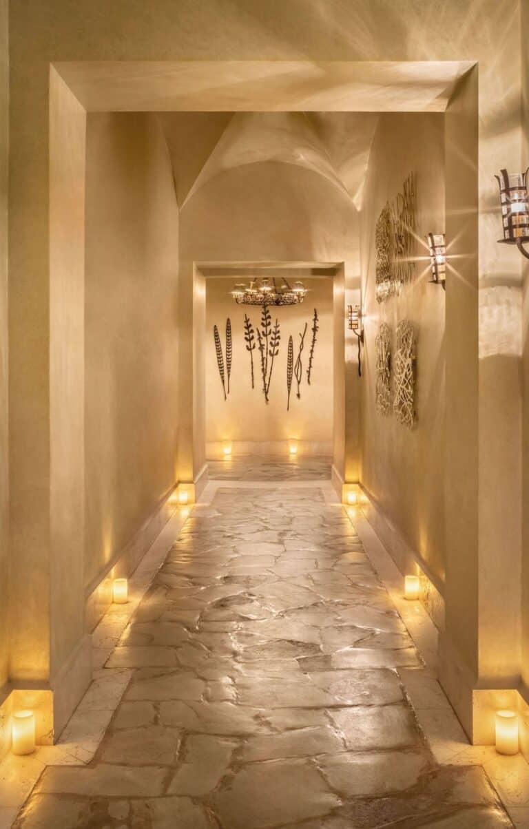 Candlelit stone corridor inside Waldorf Astoria Spa