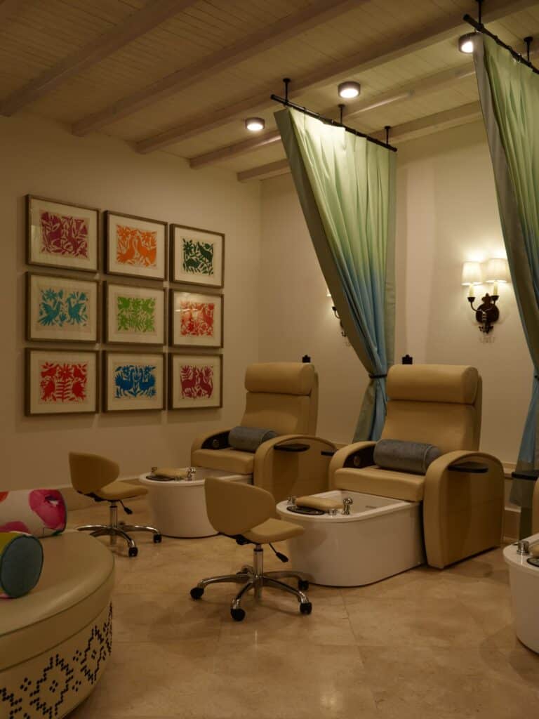 Pedicure chairs and framed embroidered textiles in the salon at Waldorf Astoria Spa