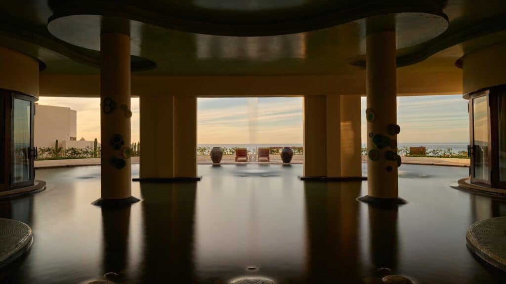 Columns rising from the spa pool, with an ocean view at sunset, at Waldorf Astoria Spa