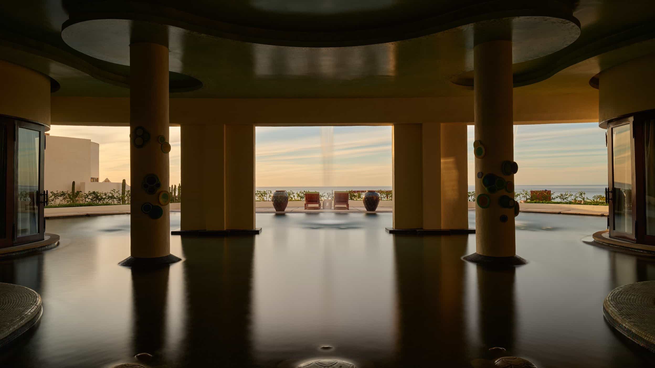 Columns rising from the spa pool, with an ocean view at sunset, at Waldorf Astoria Spa