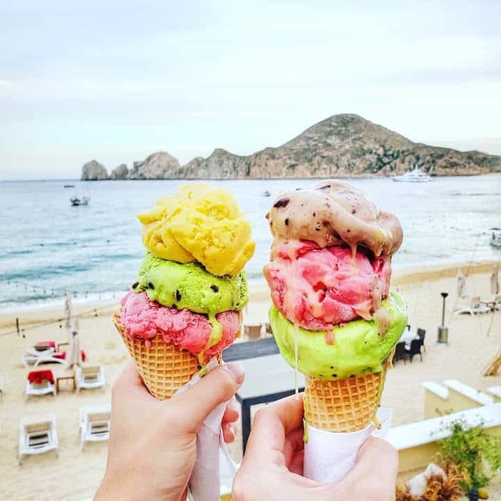 Two colorful ice cream cones held above Médano Beach.