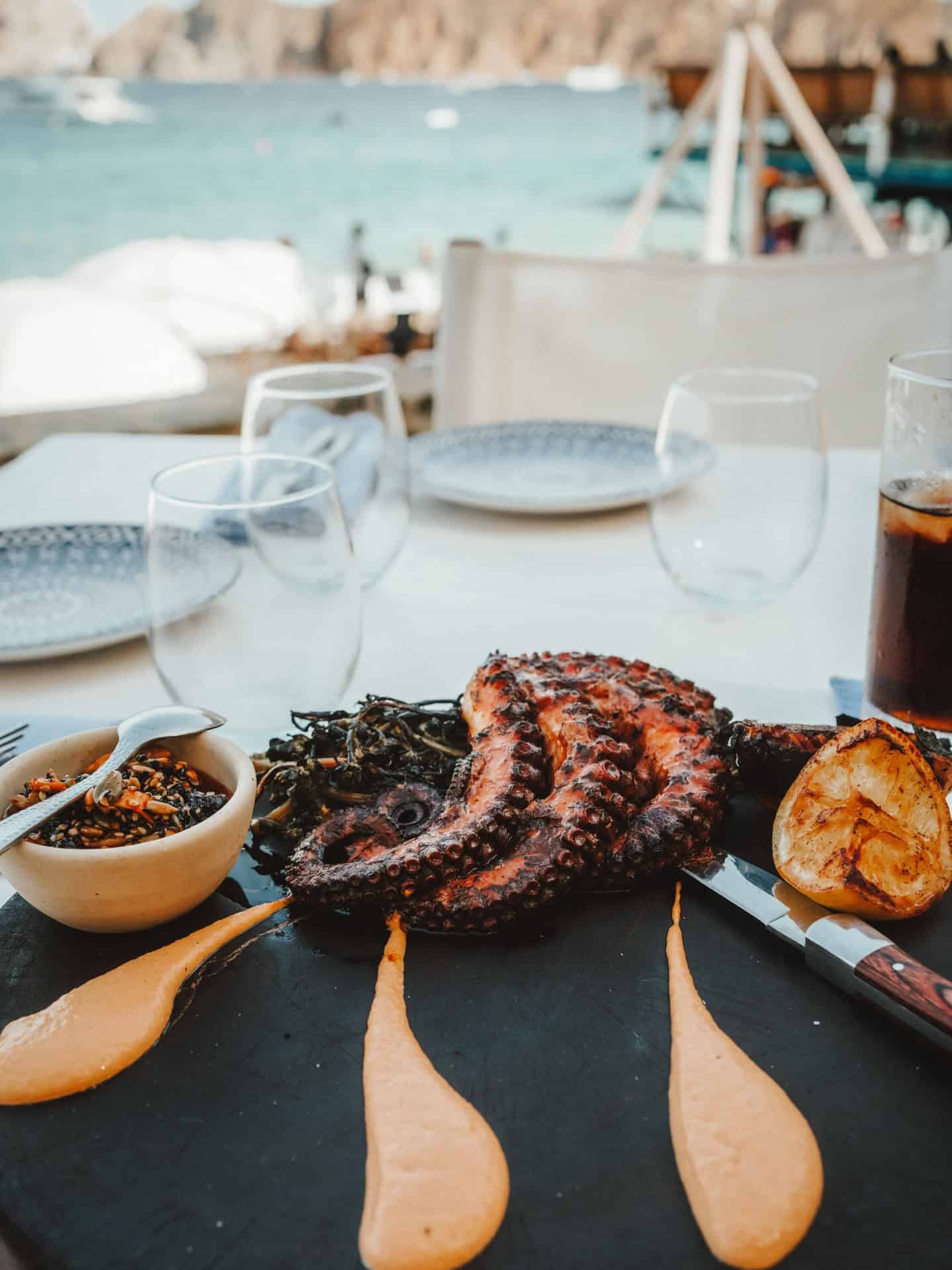 Grilled octopus served at an oceanfront table at SUR Beach House.